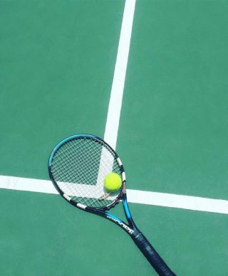 Tennis racket and a ball on a tennis field