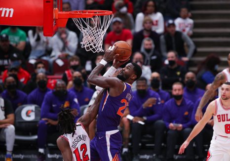 Basketball player drives to the basket for a layup during a game