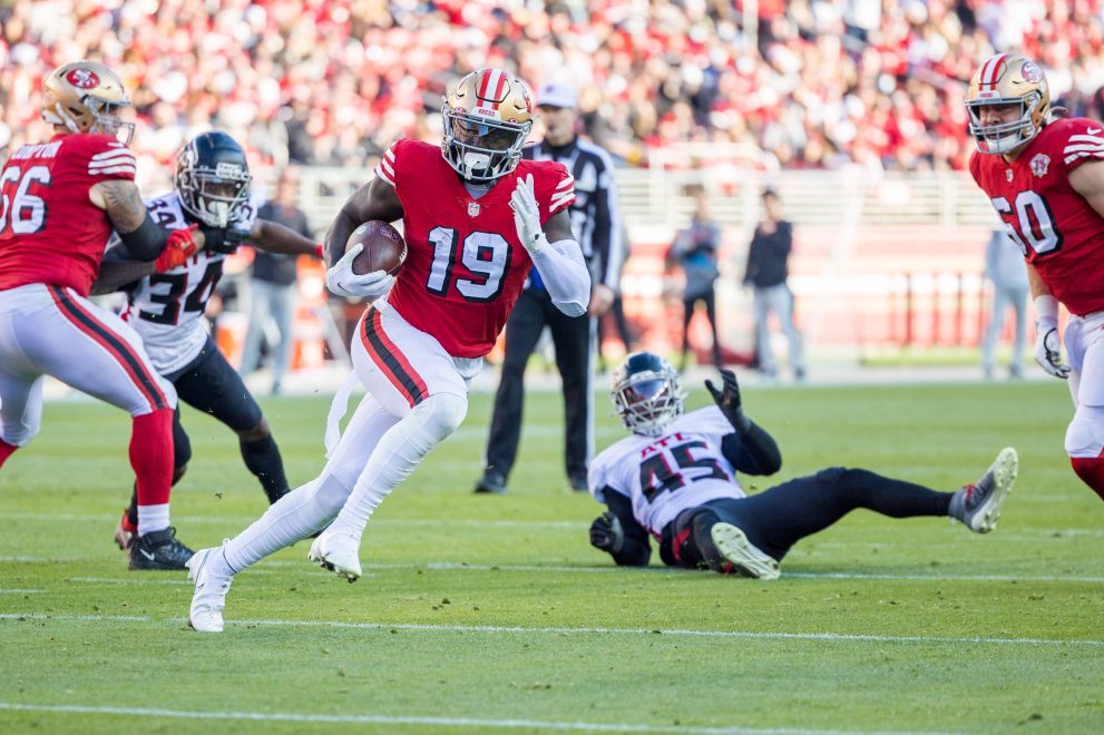 American football player finds a hole and runs the ball during a game