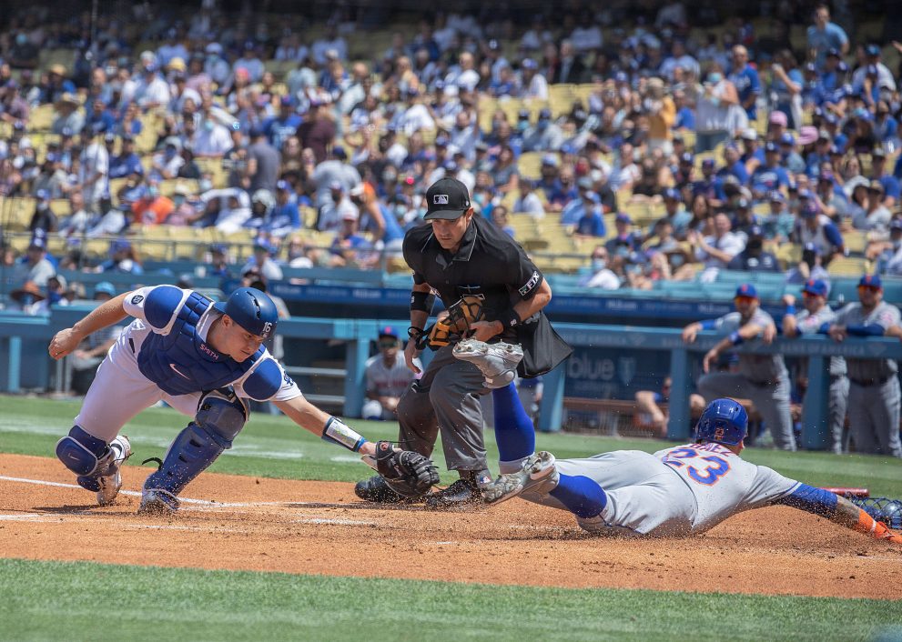 Baseball player slides into home, beating a tag during a game