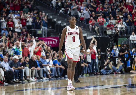 Basketball player walks over to celebrate a win with his teammates after the game