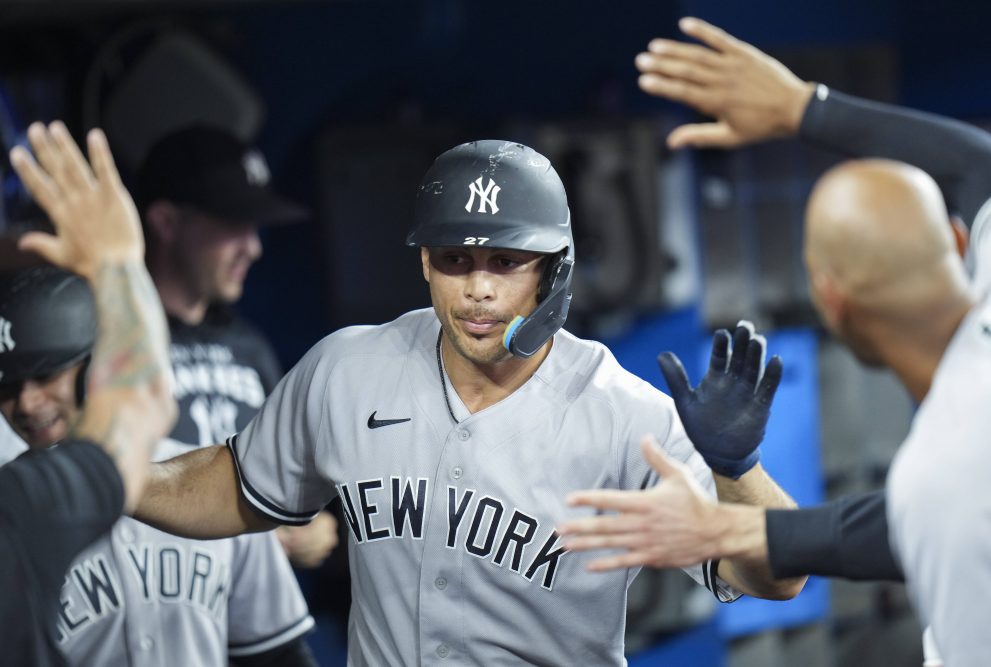 Baseball player celebrates his scored run with teammates in the dugout