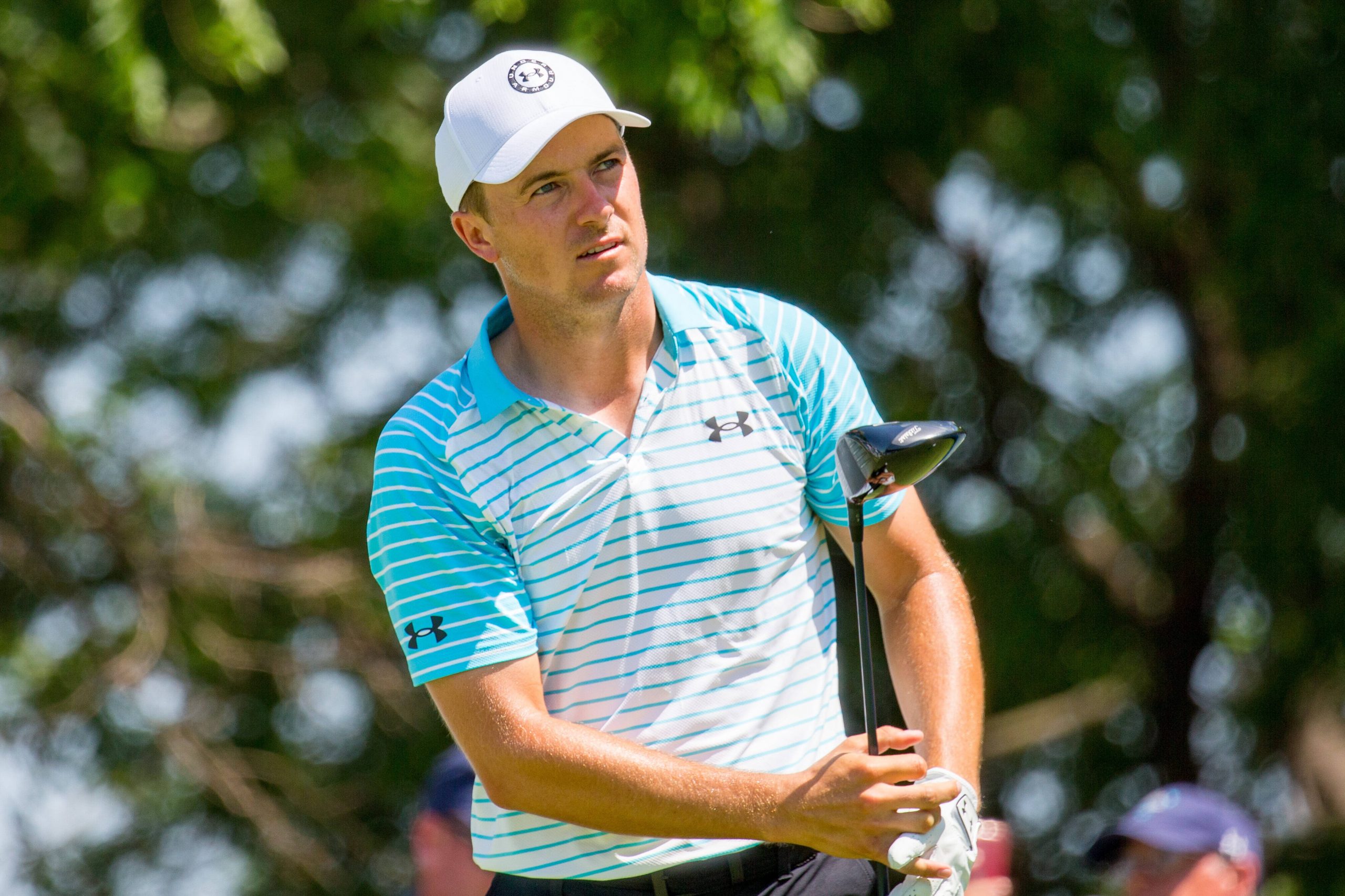 Golf player reacts after hitting his tee shot during a round of a game