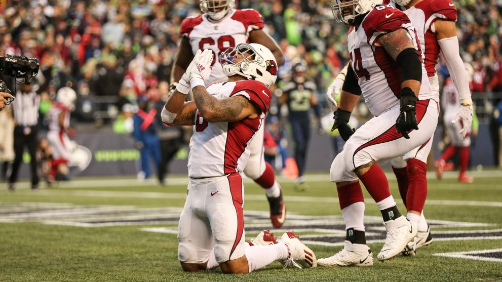 American football player thanks God after scoring