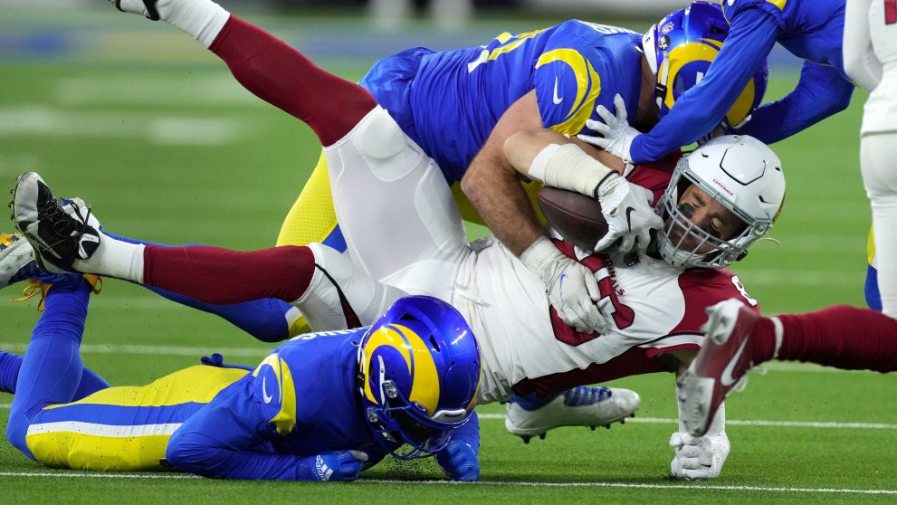 American football players tackle a player of the opposing team who has the ball