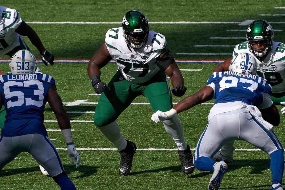 American football players tackle a player of the opposing team who has the ball