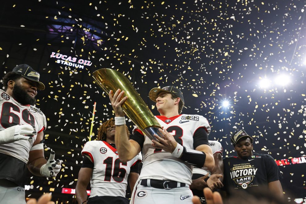 American football players celebrate a winning of a trophy