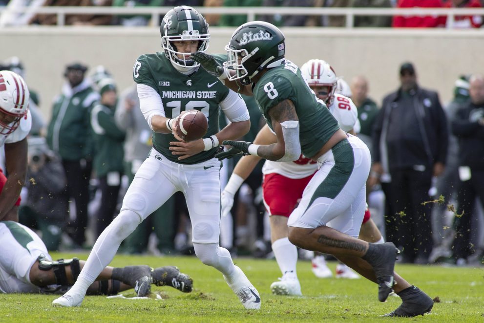 American football players pass the ball during a match