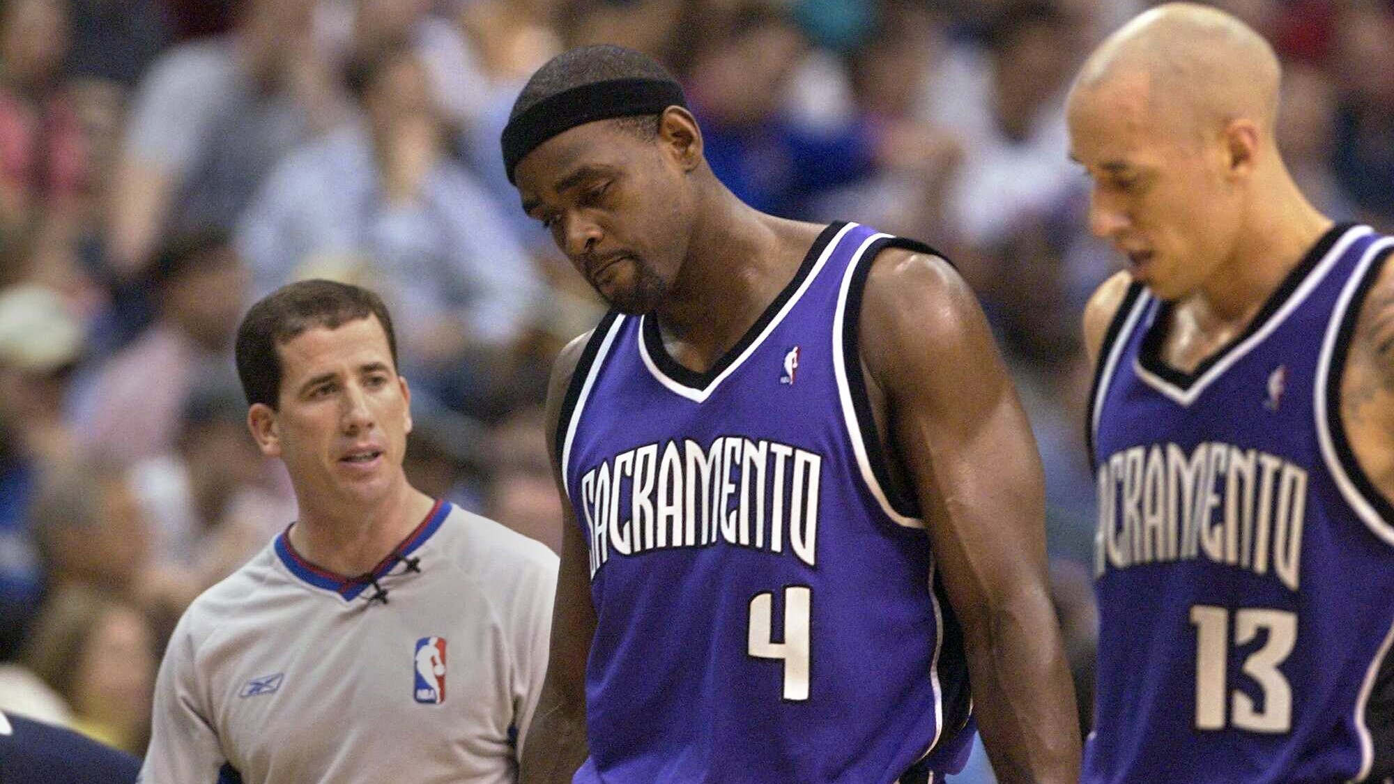 Two basketball players and the referee during a match