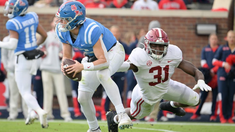 American football player carries the ball and escapes from the hands of opposite team player during a match