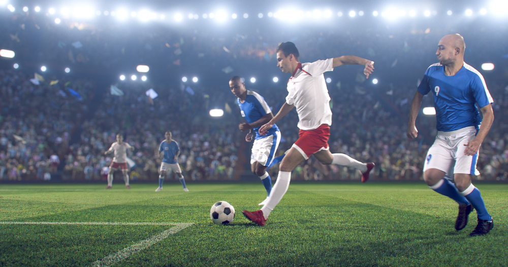 Football player kicks the ball on the football stadium during a match