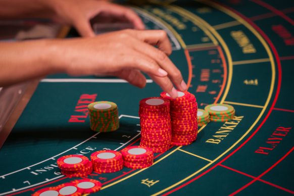 Player bets by adding casino chips on a baccarat table