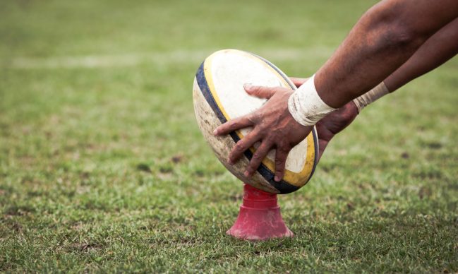 A rugby ball placed on a telescopic Kicking Tee by a player