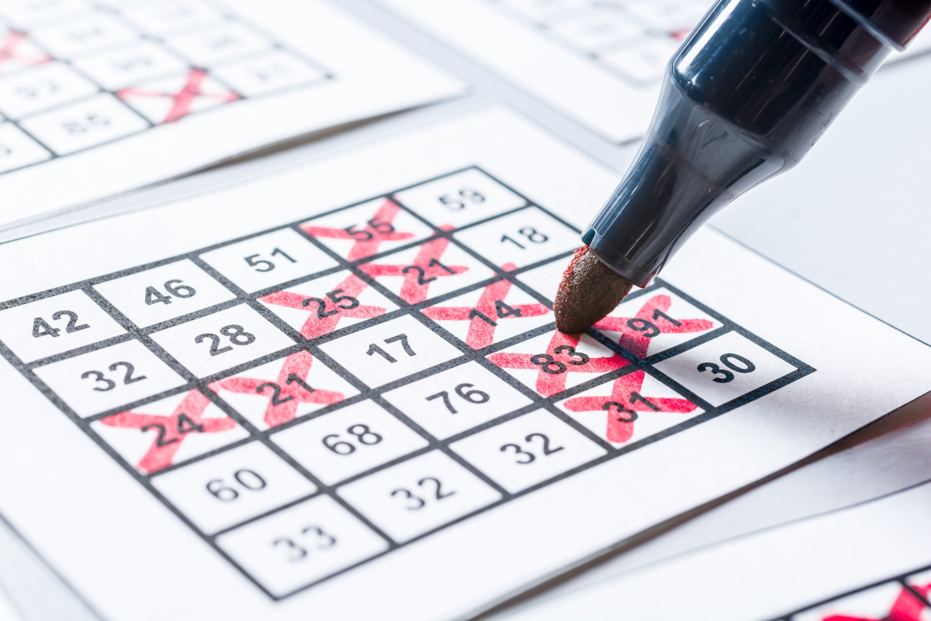 Player marks with X the winning numbers on a bingo tickets