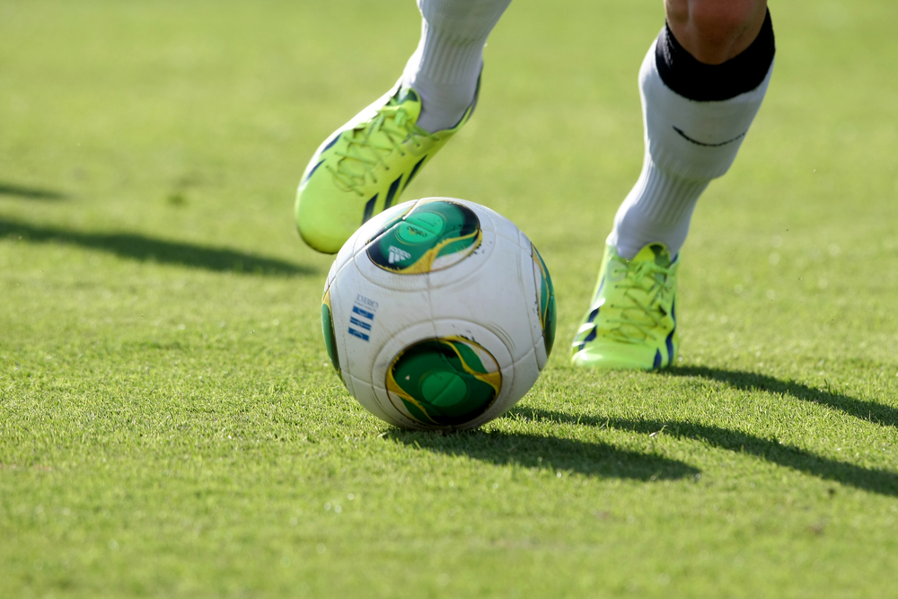 Feet of a football player run after a ball