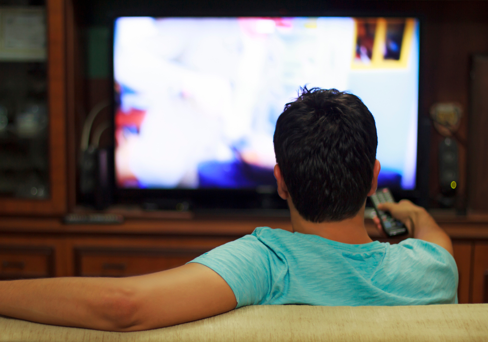 Male watching television in home living room