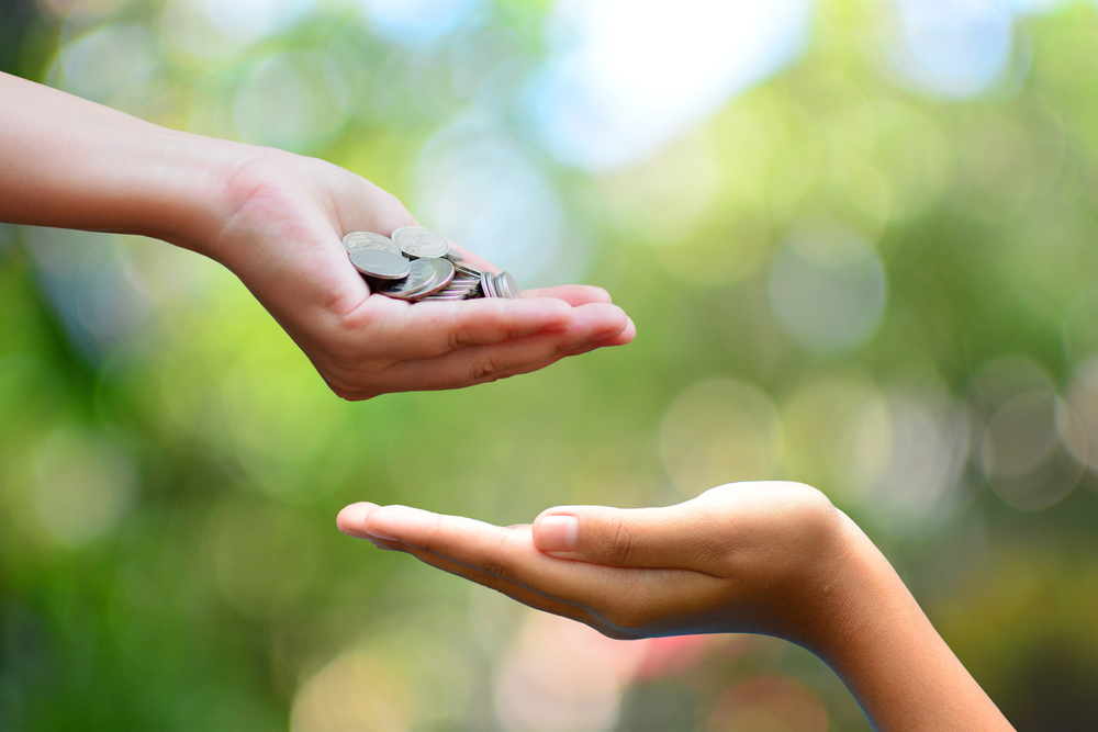 Hand full of coins on top of an empty hand