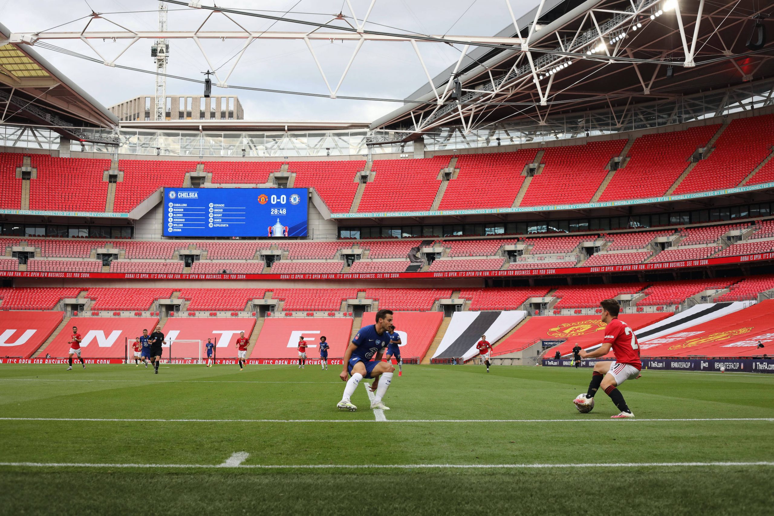 Football players play football on a stadium with empty stands