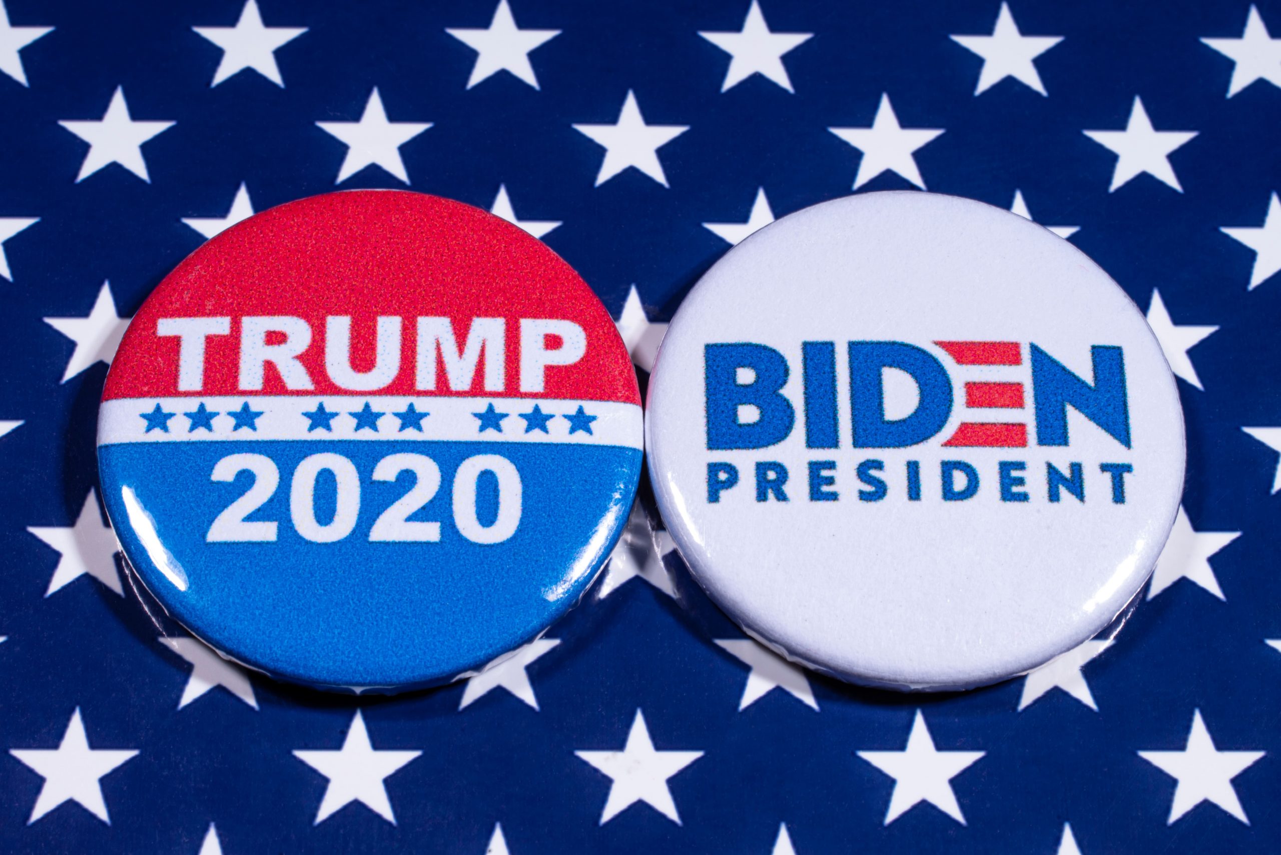 Donald Trump and Joe Biden pin badges, pictured of the USA flag.-min