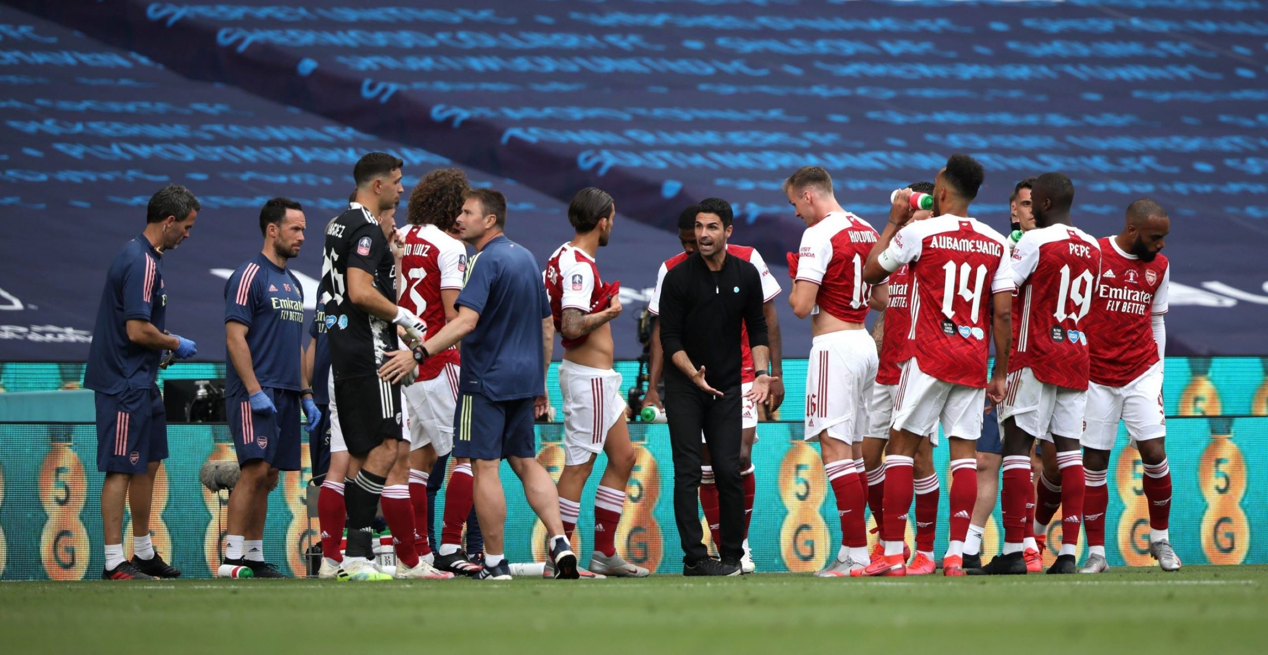 The manager talks to his football players during a water time-out