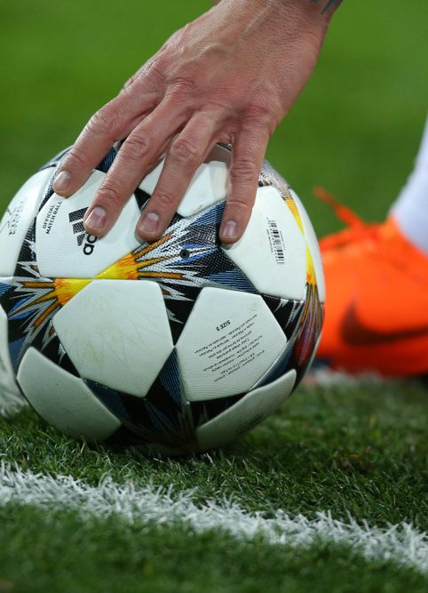 Football player fixes the ball on the field