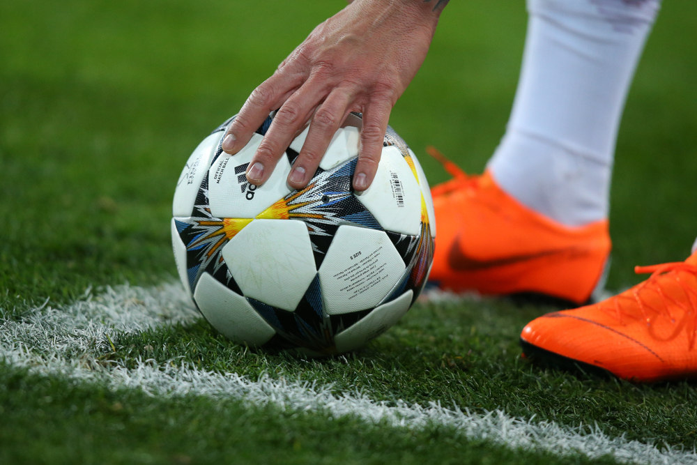 Football player fixes the ball on the field