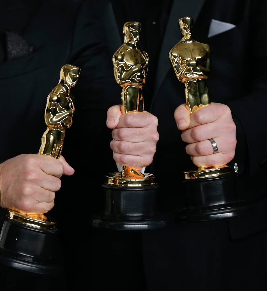 Three Oscar winners with their Oscar statues in their hands