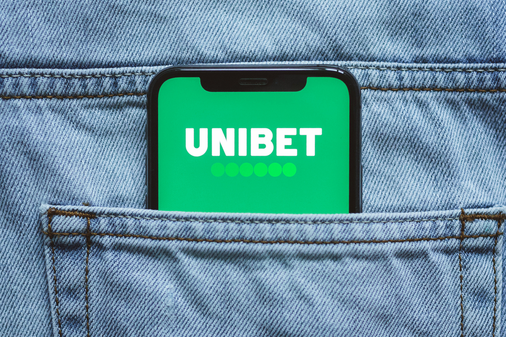 Unibet betting app logo on the mobile phone screen in jeans pocket