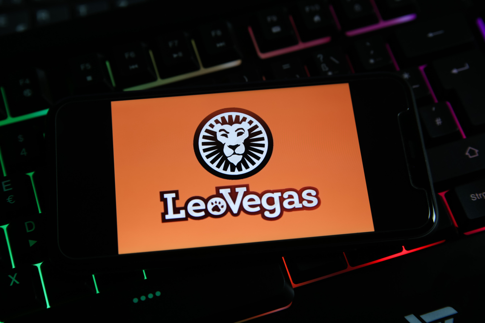 Smartphone screen with the LeoVegas logo on a lighted keyboard