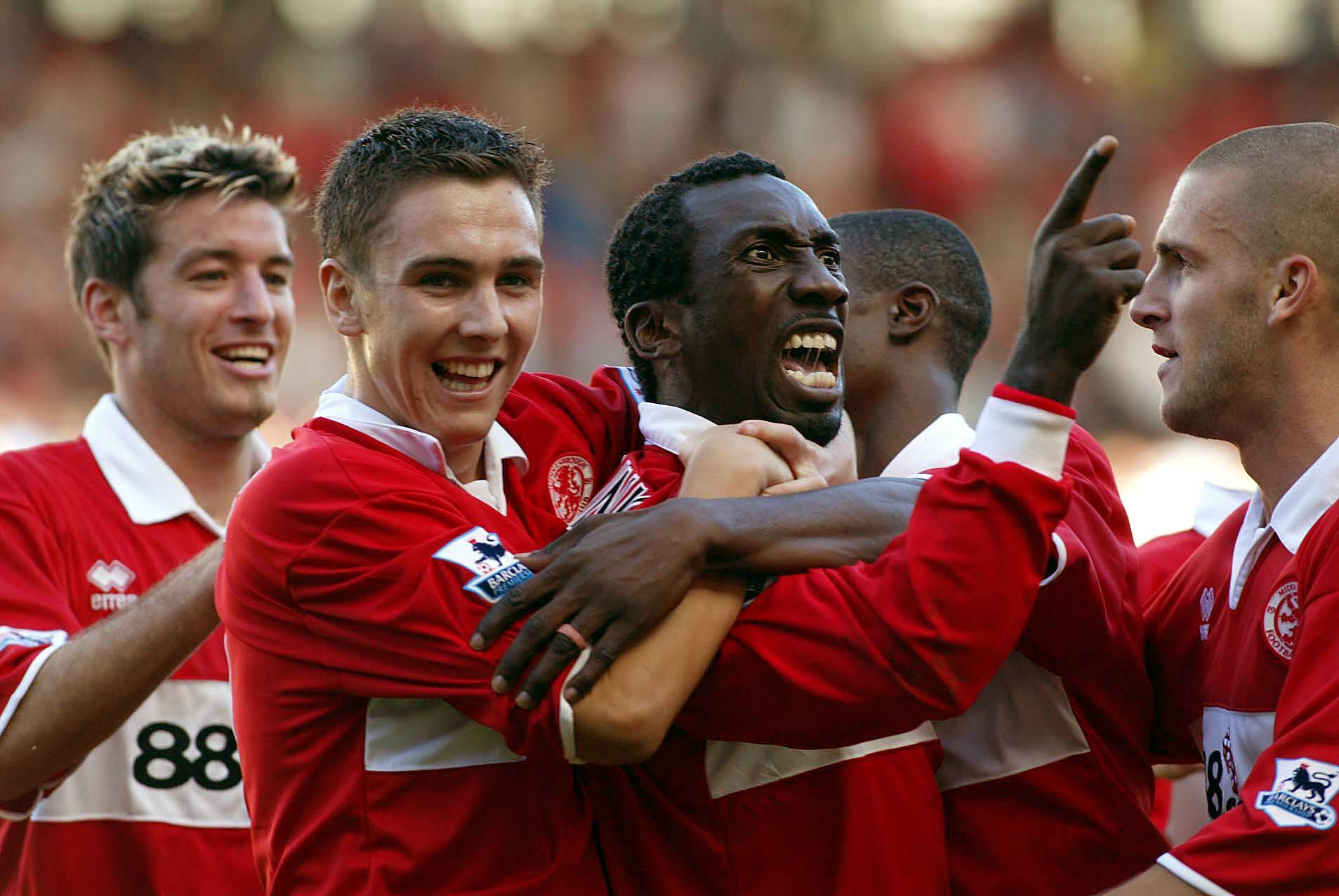 Five football players celebrate after scoring a goal