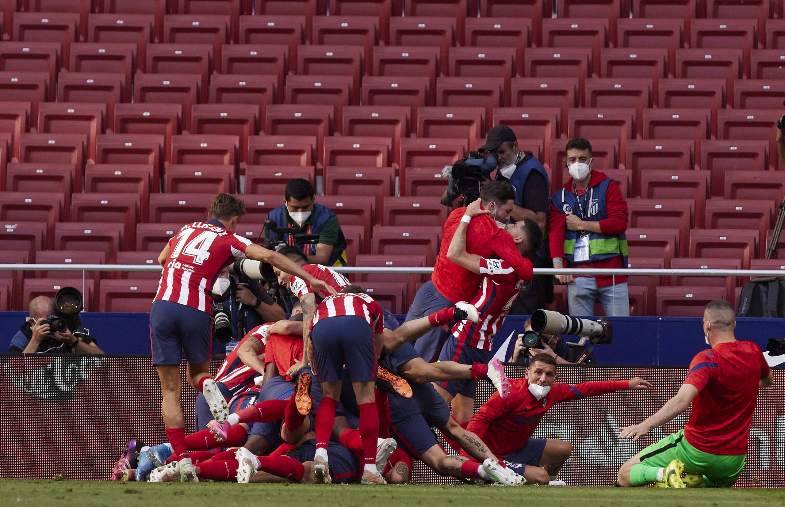 Football players celebrate after scoring a goal during a match in a pandemic time