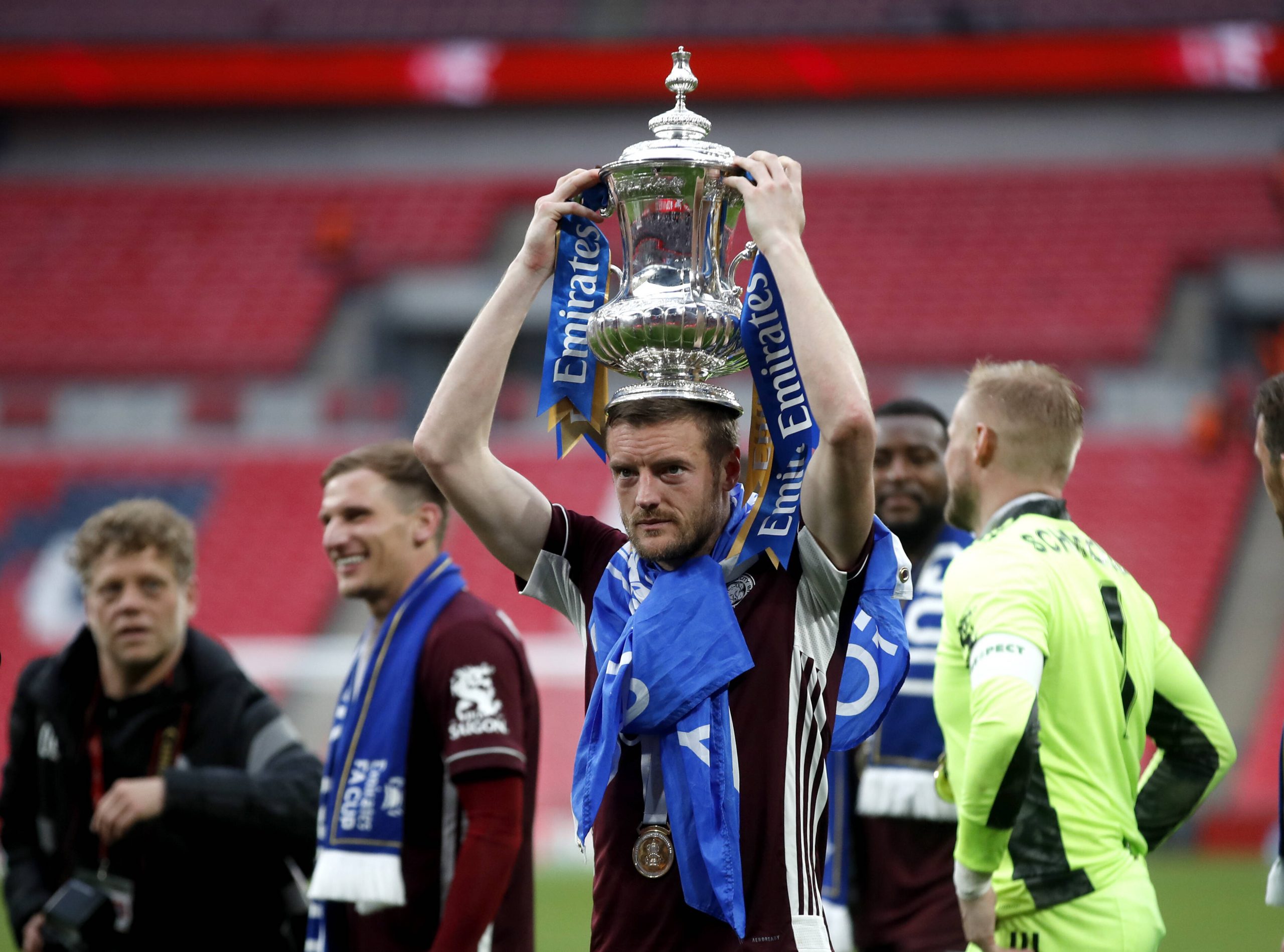 Football player celebrates FA Cup victory by keeping the trophy on his head