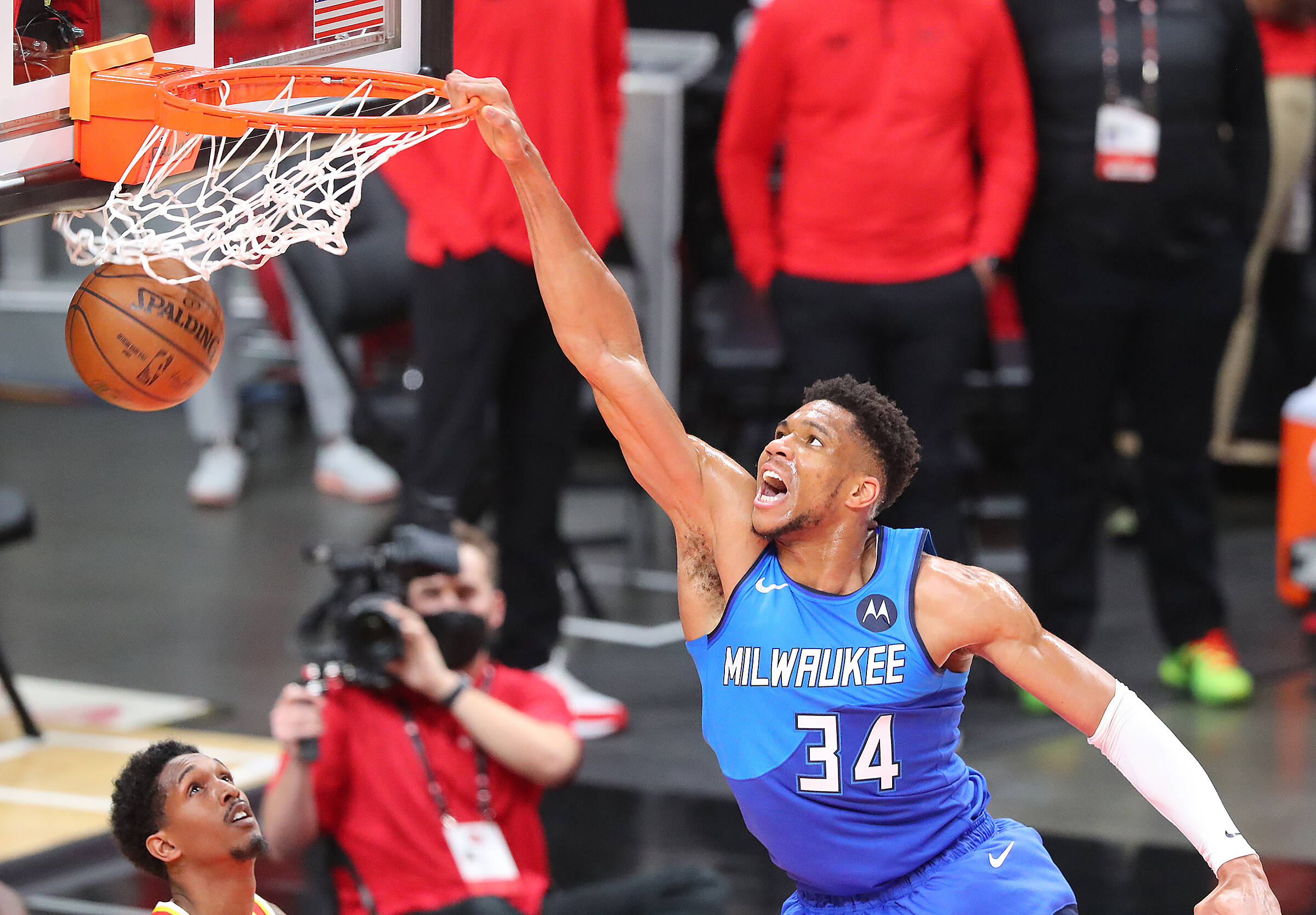 Basketball player hangs on the rim after a dunk