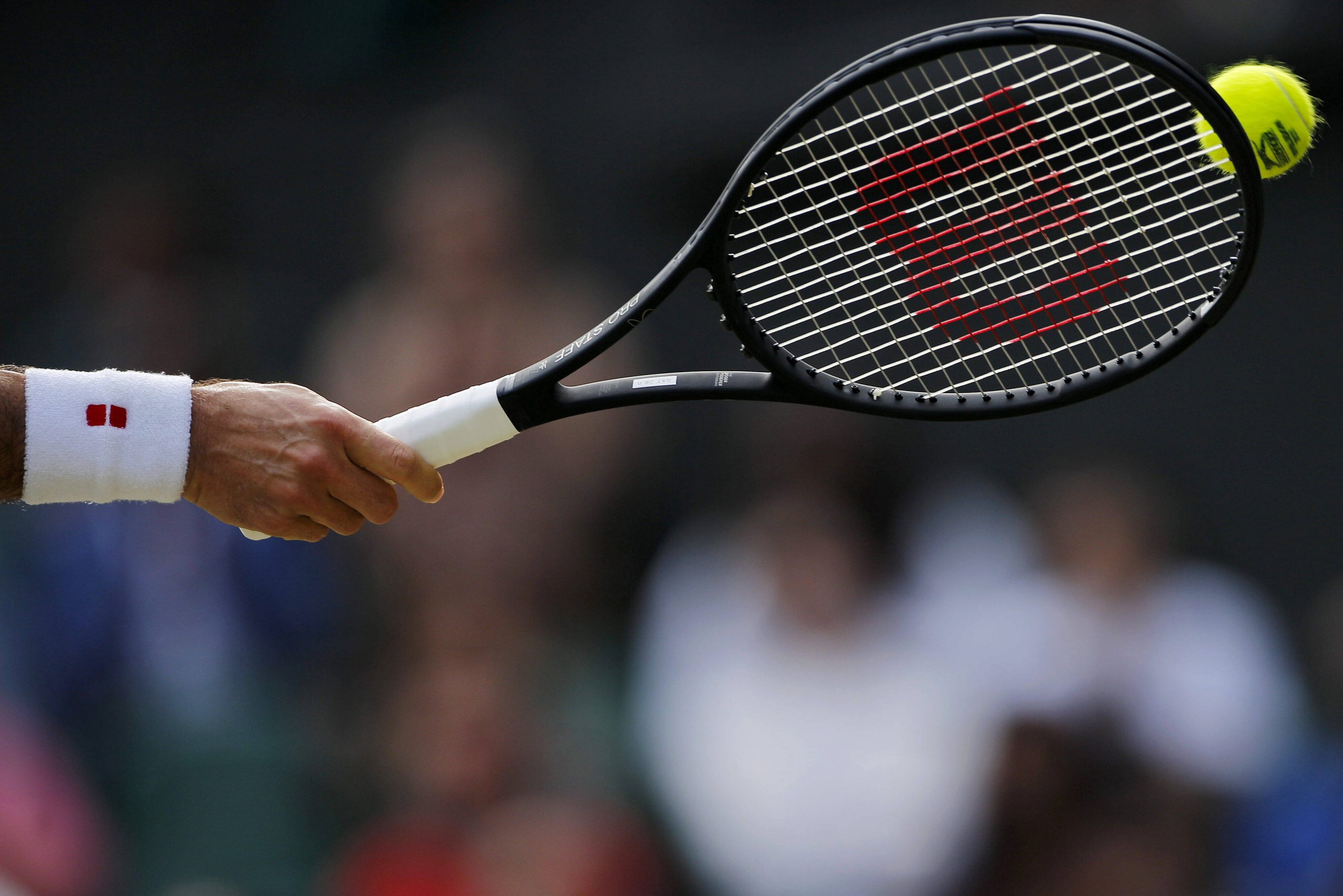 Tennis player's hand with a tennis racket hitting a ball