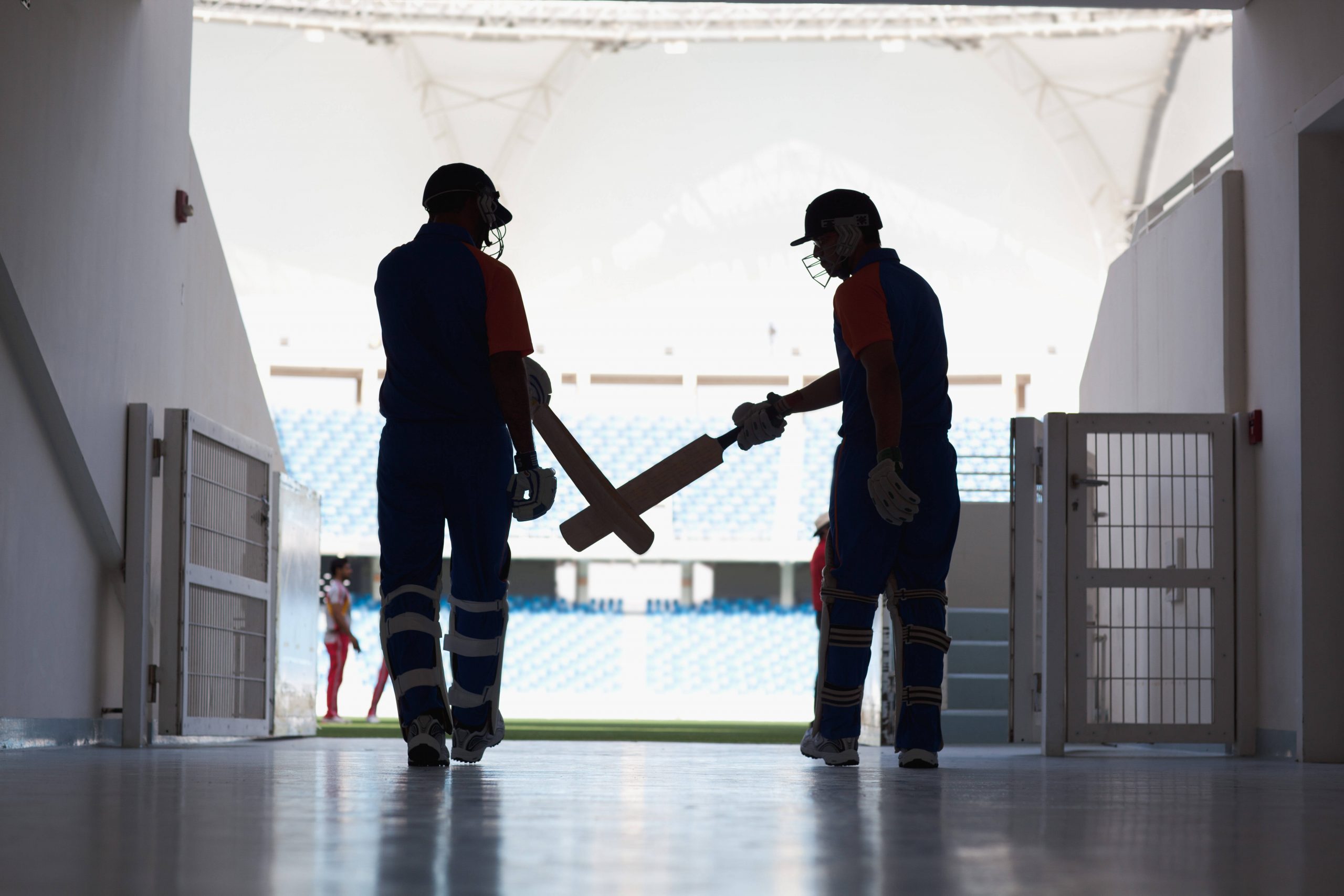 Cricket batsmen entering ground.