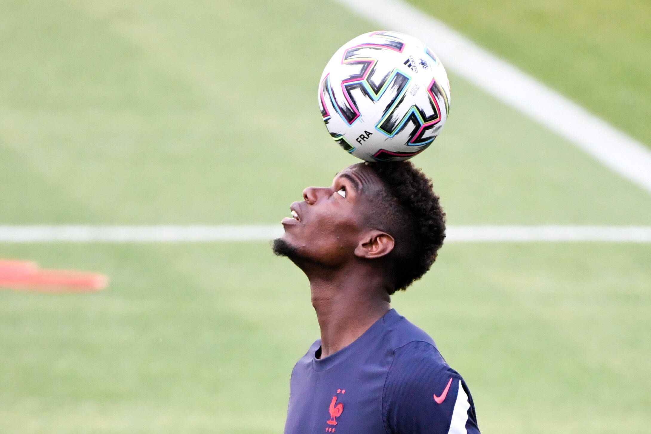 Football player juggles with ball on head