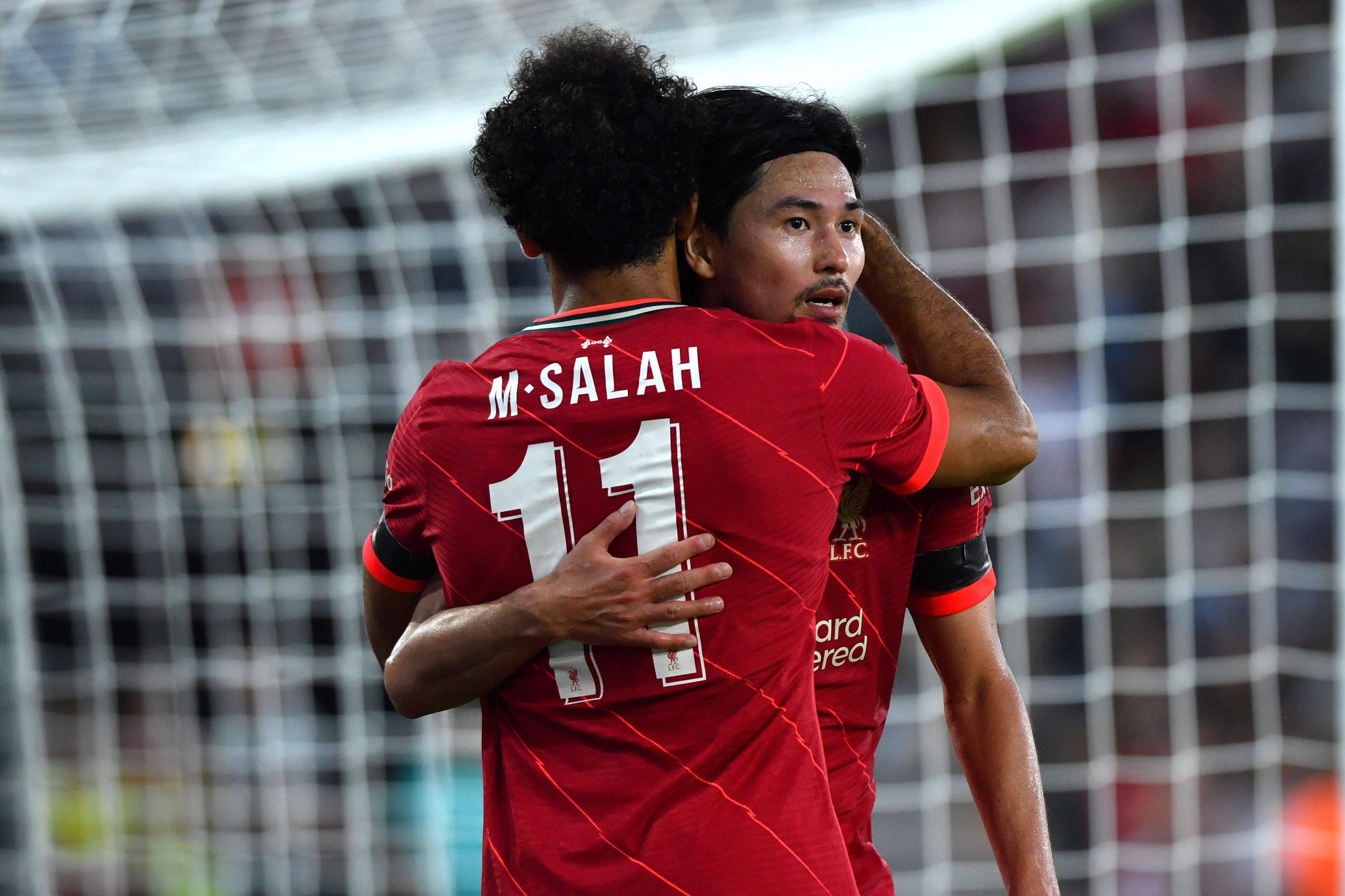 Two football players hug celebrating a goal