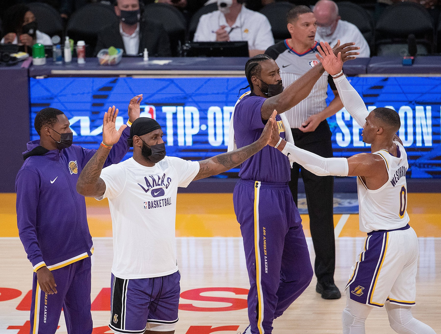 Basketball bench team gives five with their team mate