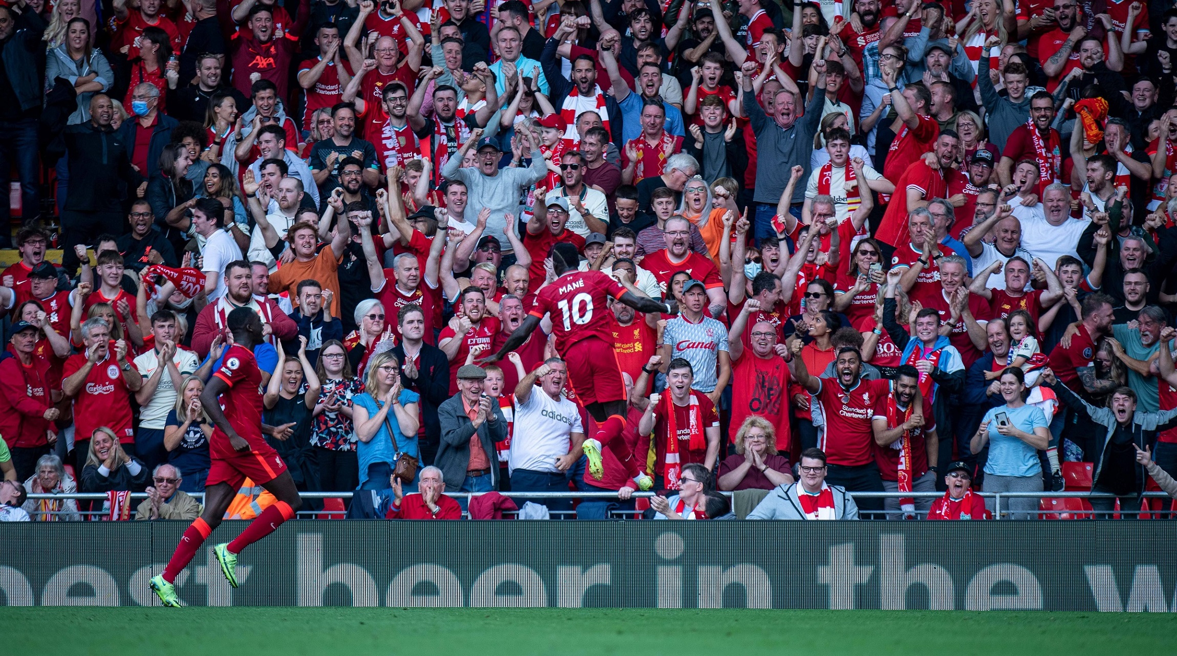 Football players celebrate a goal celebrate a goal with their fans in the stands