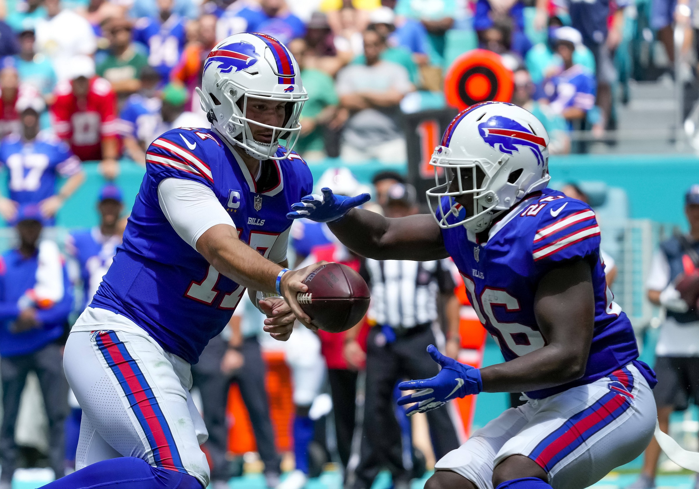 American football players pass the ball during a game