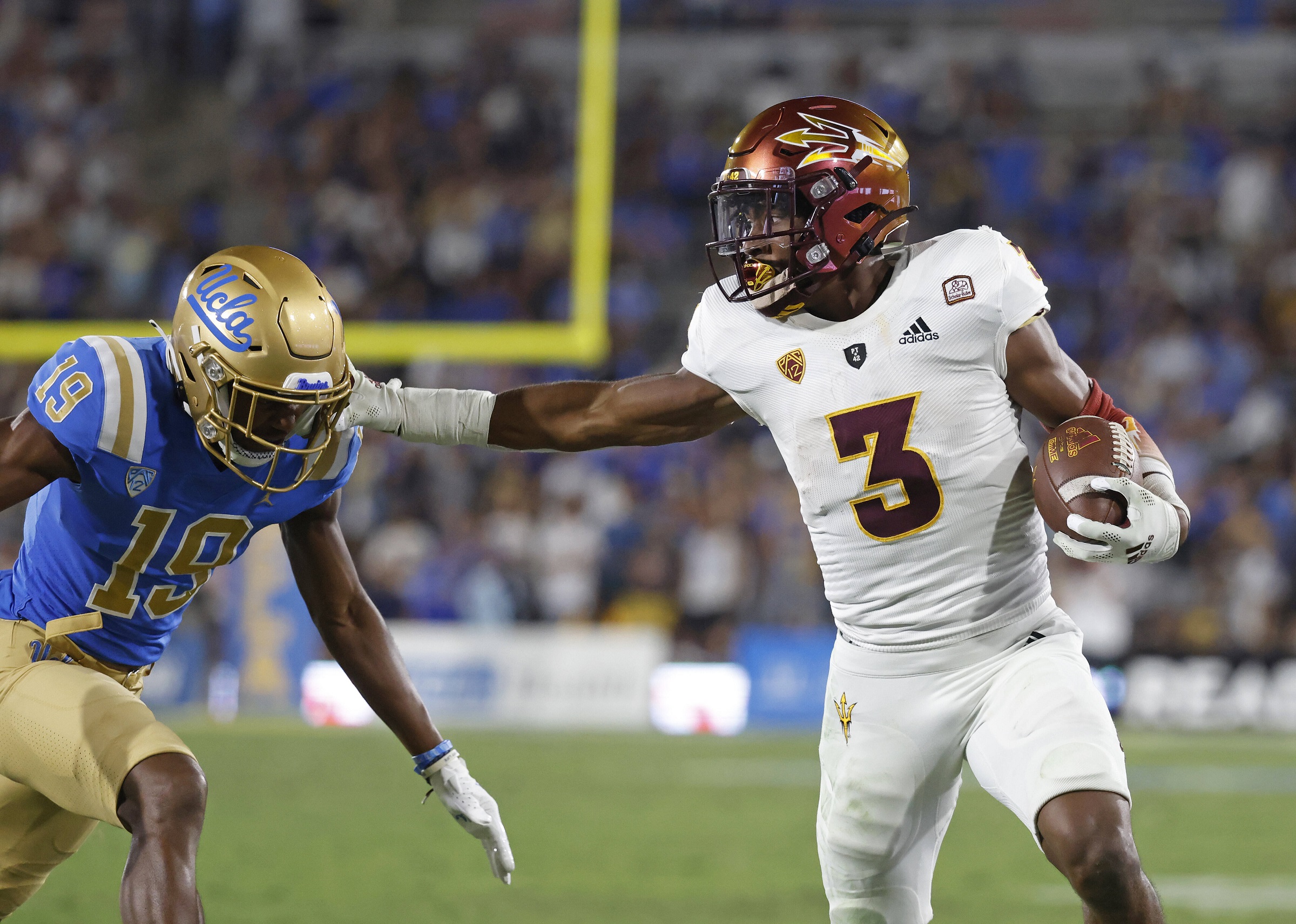 An american football player runs back his opponent team player who carries the ball and scores a touchdown