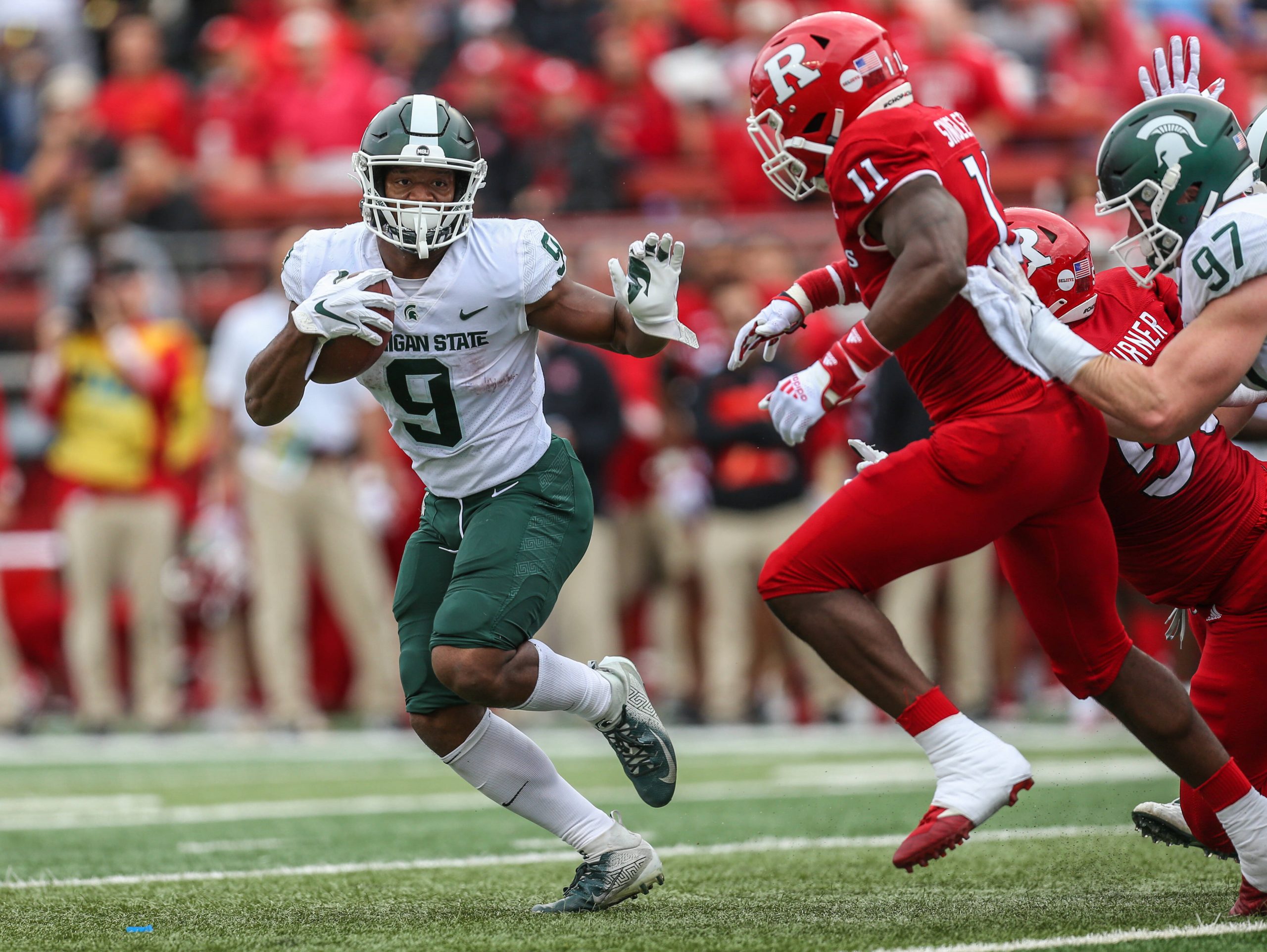 An american football player looks for room to run during a game