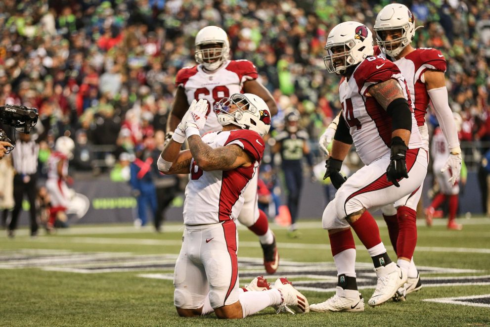 Four american football player celebrate a touchdown