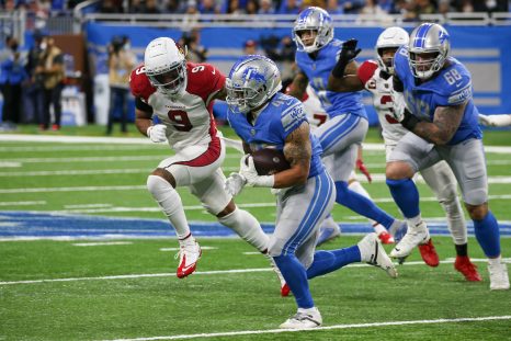 American football player runs with the ball while being pursued by the players of the opponent team