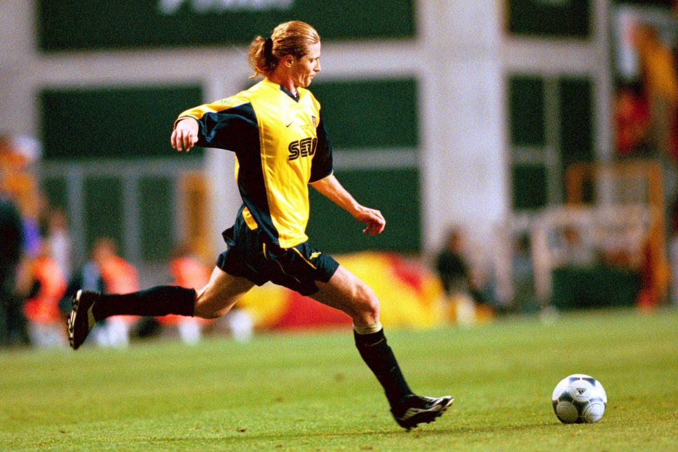 Emmanuel Petit kicking a ball playing for Arsenal.